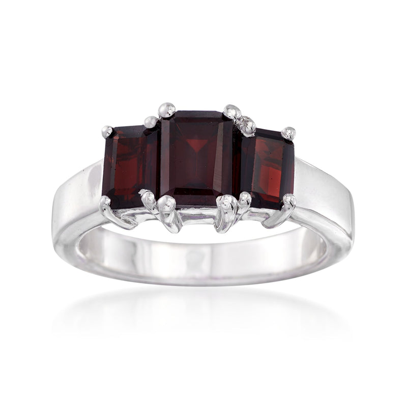 Sterling silver three-stone ring with dark red emerald-cut garnet and round clear accents