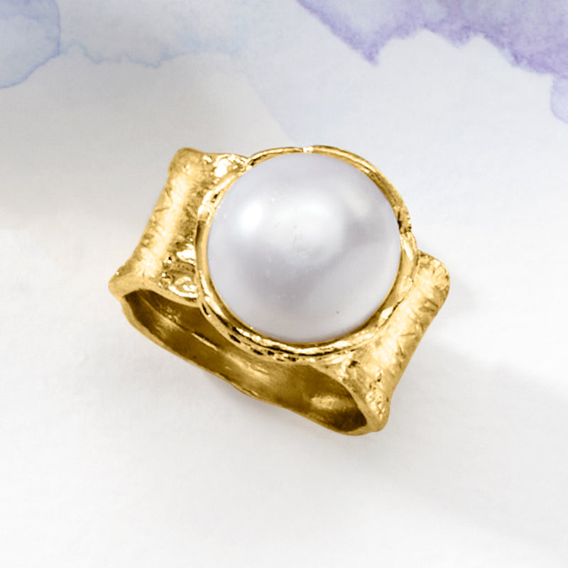 Gold-tone ring with round white pearl center and engraved wraparound shoulders