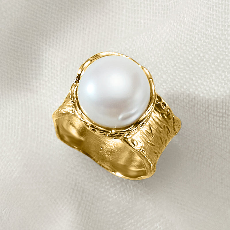 Gold-tone ring with round white pearl in textured split shoulders