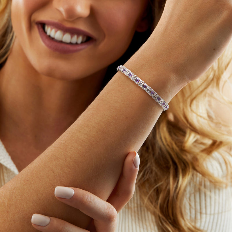 Sterling silver amethyst bracelet on wrist with oval purple stones