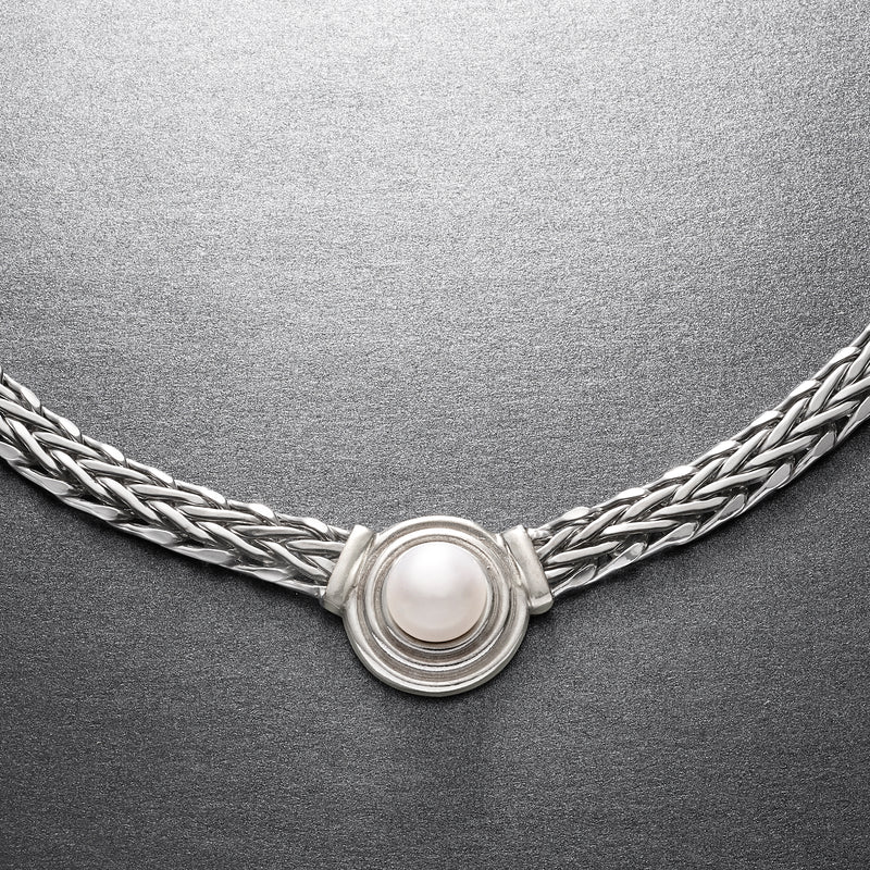 Close-up of sterling silver wheat-chain necklace with round cultured pearl pendant