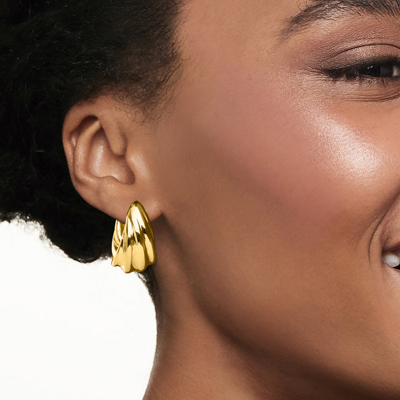 Twisted gold over sterling hoop earring on ear, polished curved ridges