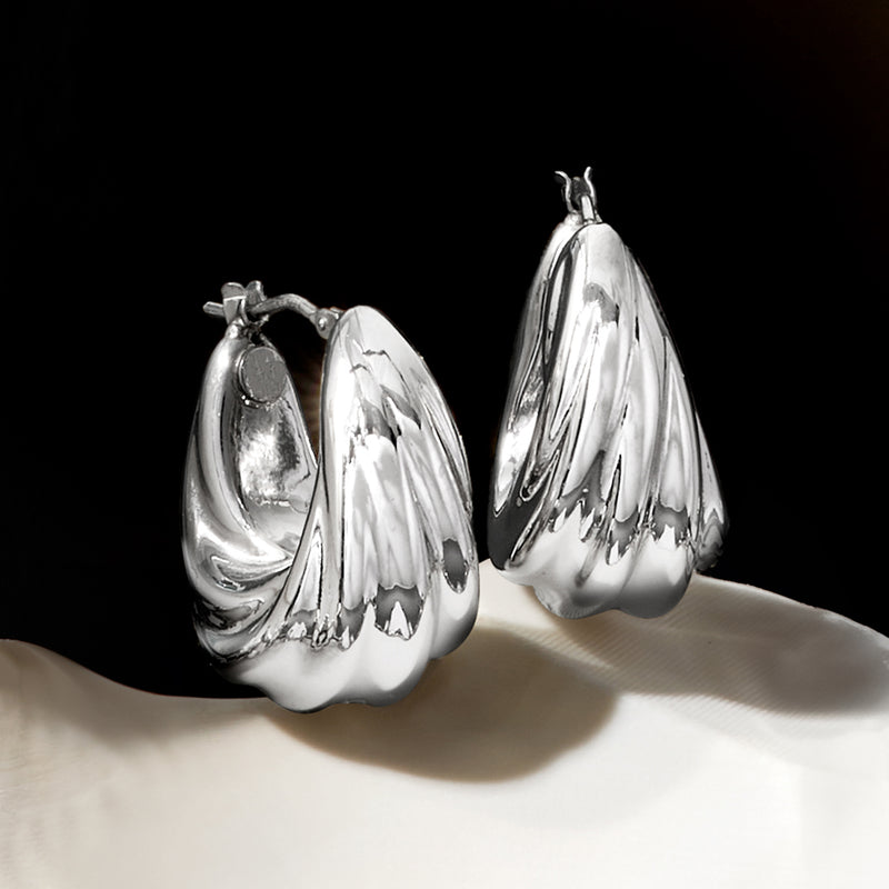 Twisted silver hoop earrings with polished spiral texture and rounded hoop shape