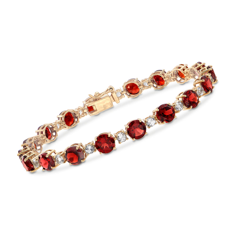 Garnet tennis bracelet with oval red stones and clear accents, yellow gold over silver