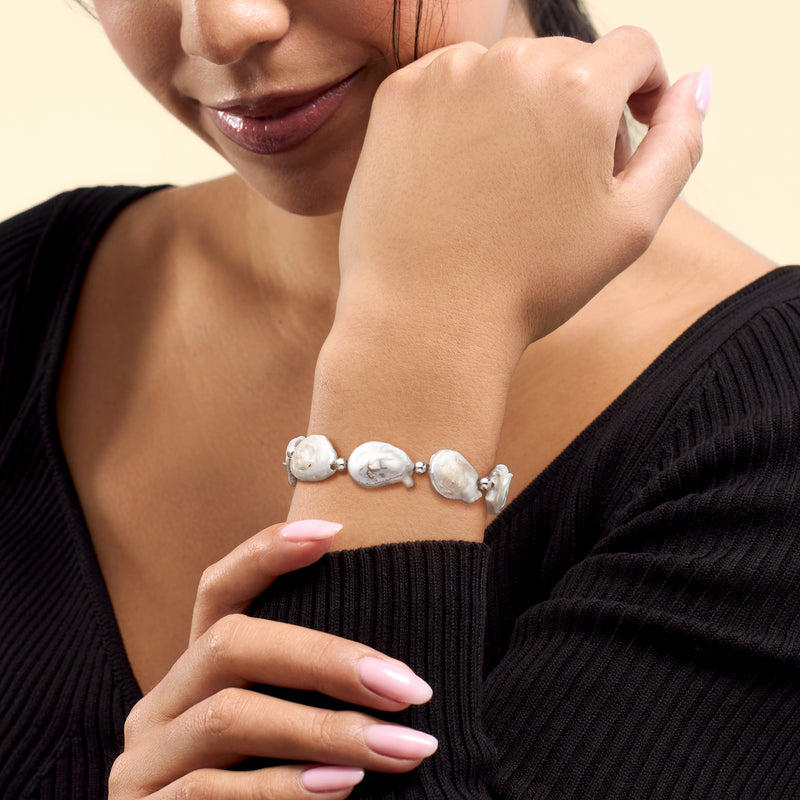 Cultured baroque pearl stretch bracelet on wrist with white pearls and silver clasp links