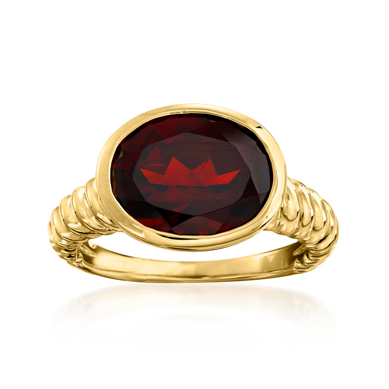 Oval garnet ring with dark red oval stone, gold-tone bezel and twisted band
