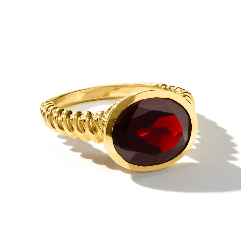 Oval garnet ring with dark red oval gemstone, gold-tone bezel and twisted shoulders