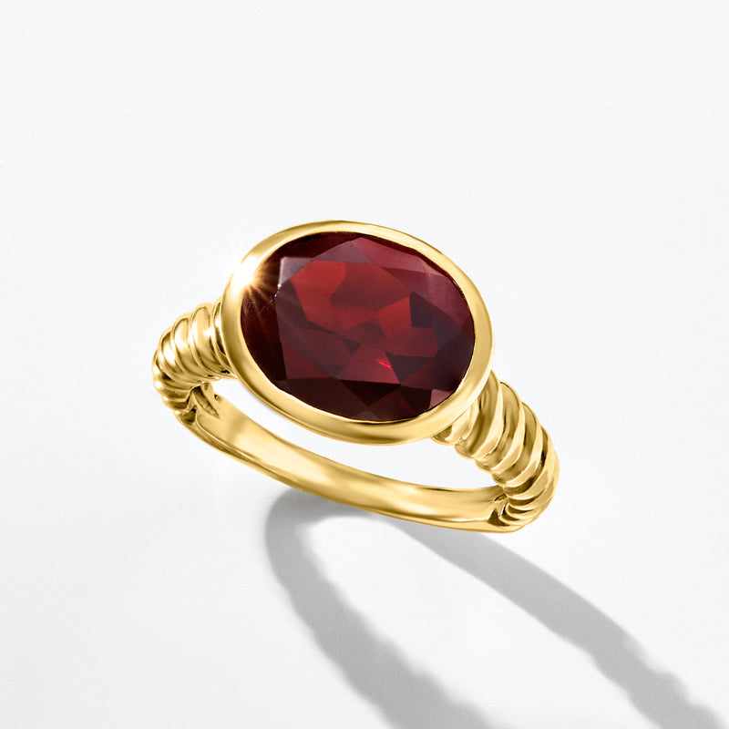 Oval garnet ring with dark red oval gemstone, gold-tone bezel and twisted shank