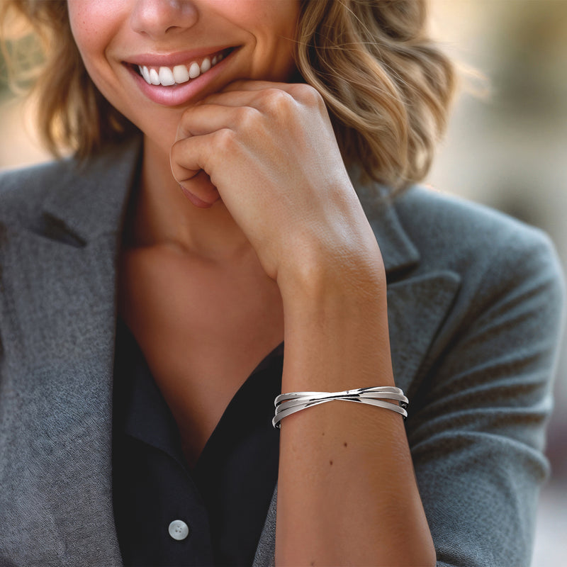 Sterling silver rolling bangle bracelet on wrist, stacked polished bands
