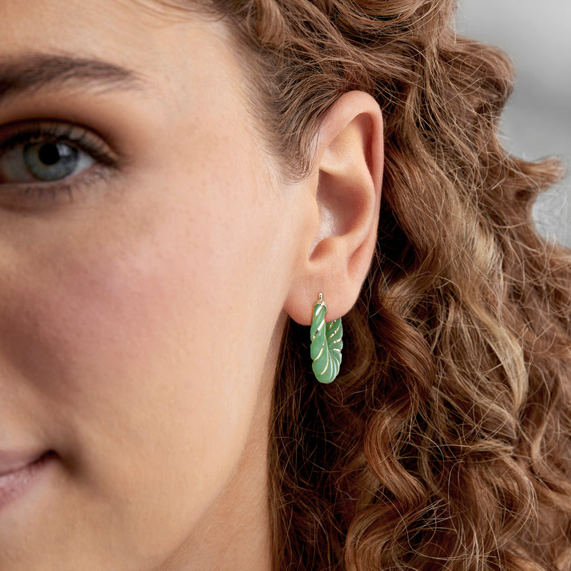 Carved jade hoop earring on ear, mint green twisted oval with 14kt yellow gold