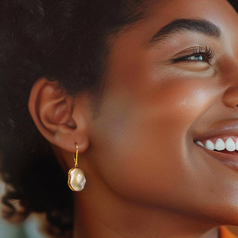 Worn gold leverback drop earrings with white teardrop keshi pearls