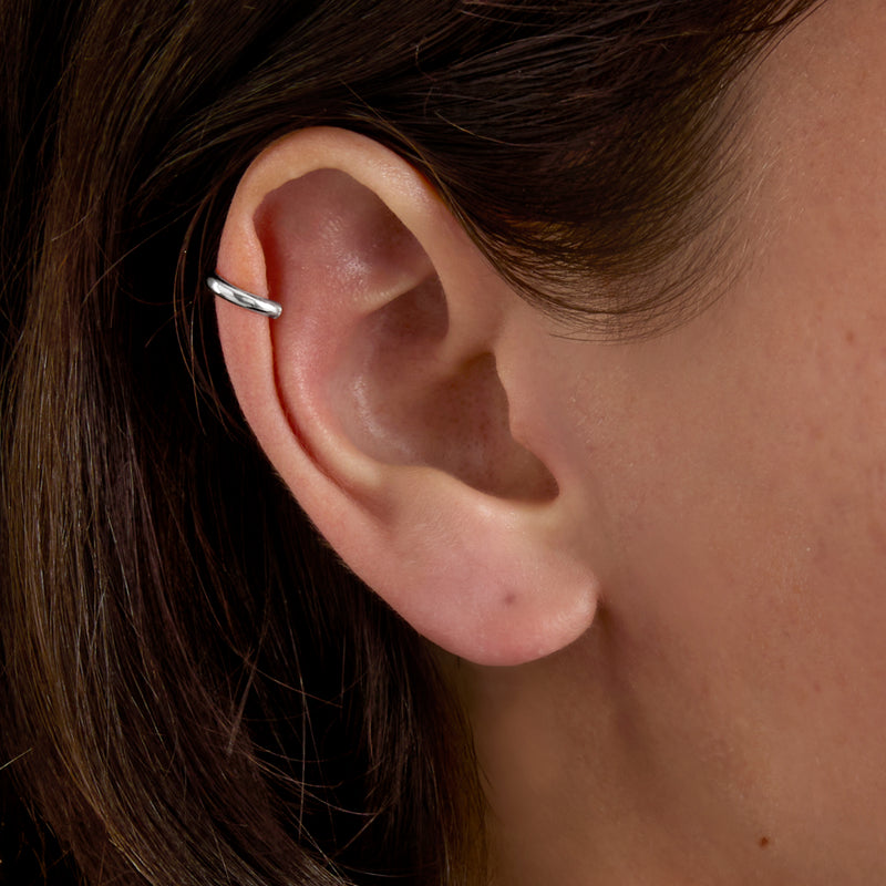 Polished white gold ear cuff on ear, smooth open C-shape band