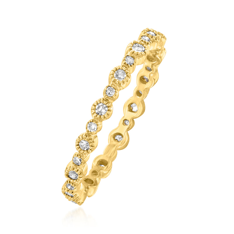 Yellow gold diamond eternity band, angled view with round bezel-set stones