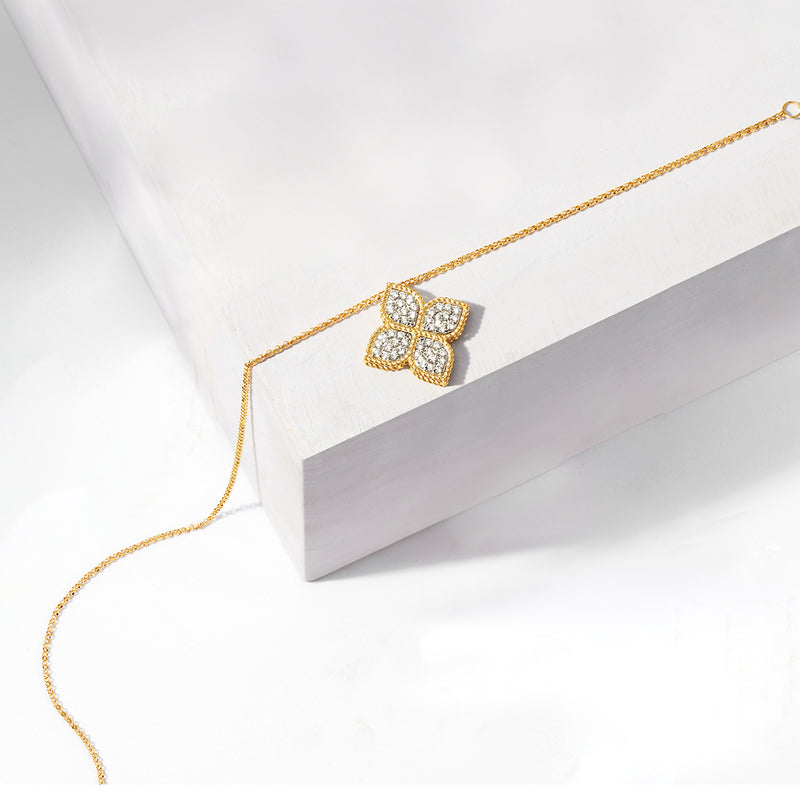 18kt yellow gold diamond flower pendant on chain, close-up view