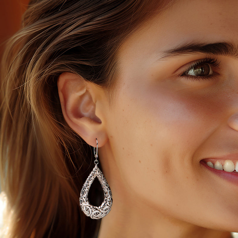 Sterling silver teardrop Byzantine hoop earrings on ear, leverback closures
