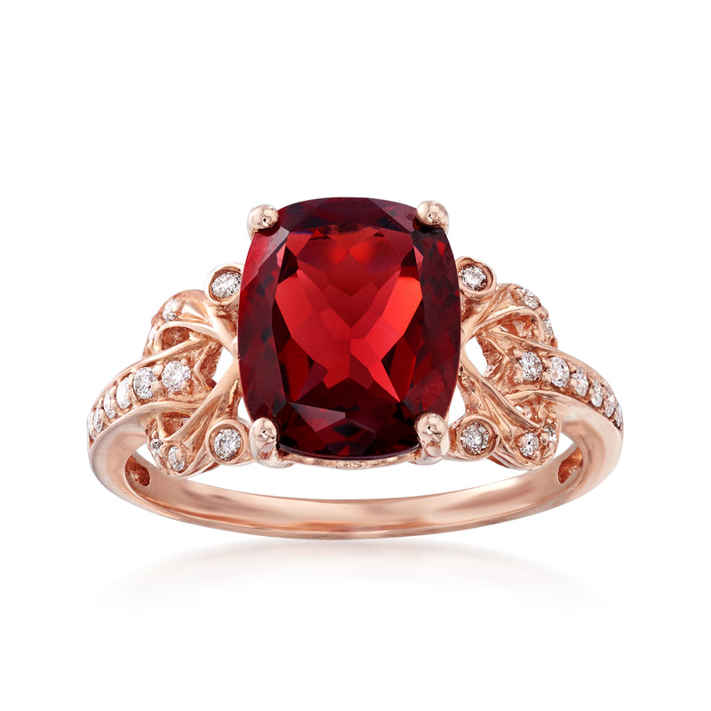 14kt rose gold ring with oval red garnet center and round diamond accents on shoulders