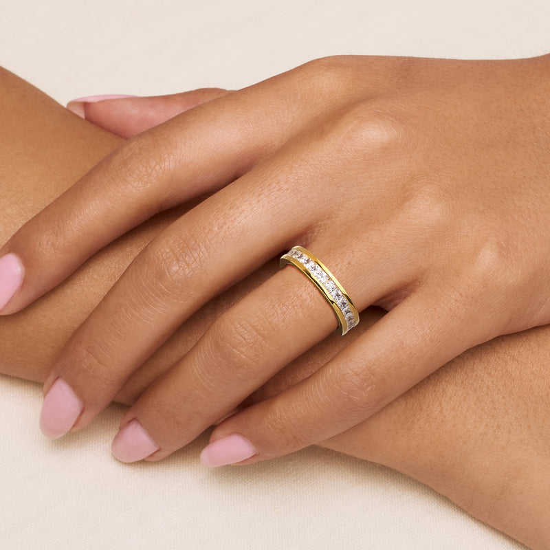 CZ eternity band ring on hand, yellow gold tone with sparkling white stones
