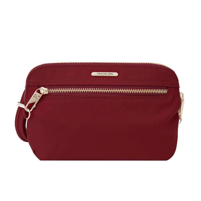 Garnet-red nylon twill crossbody clutch with Travelon logo, top zip and shoulder strap