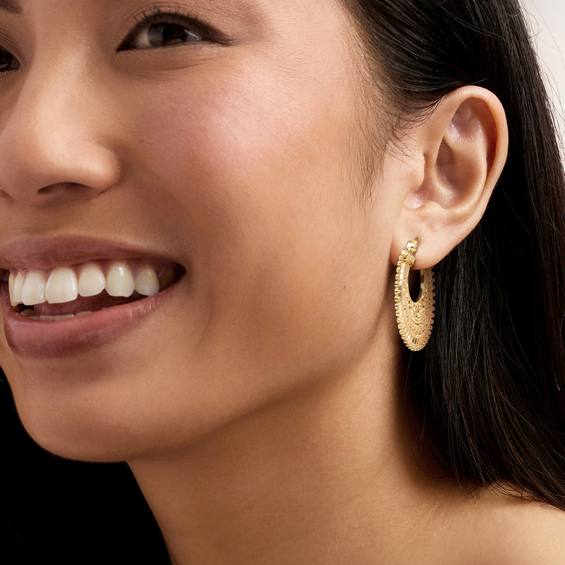 Gold hoop earrings with filigree pattern and bead-like outer border