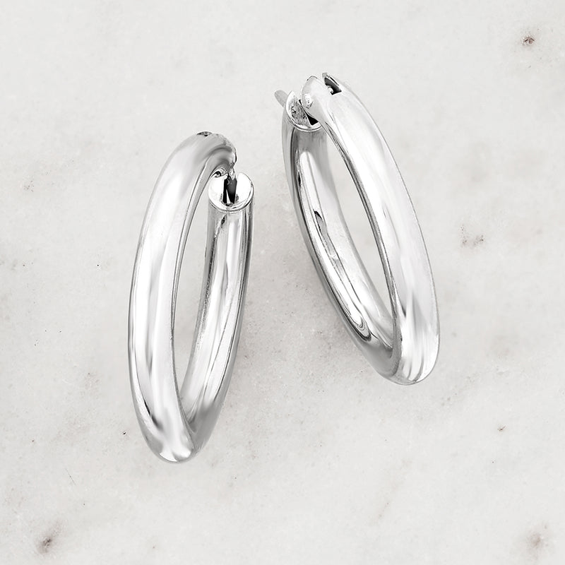 Sterling silver hoop earrings with hinged opening, reflective round profile