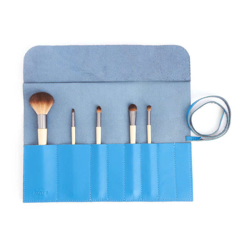 Light blue leather makeup brush roll with 6 brush sleeves and wrap strap