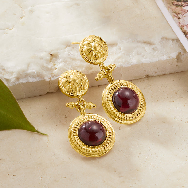 Gold floral drop earrings with two round burgundy stones and dangling chain details
