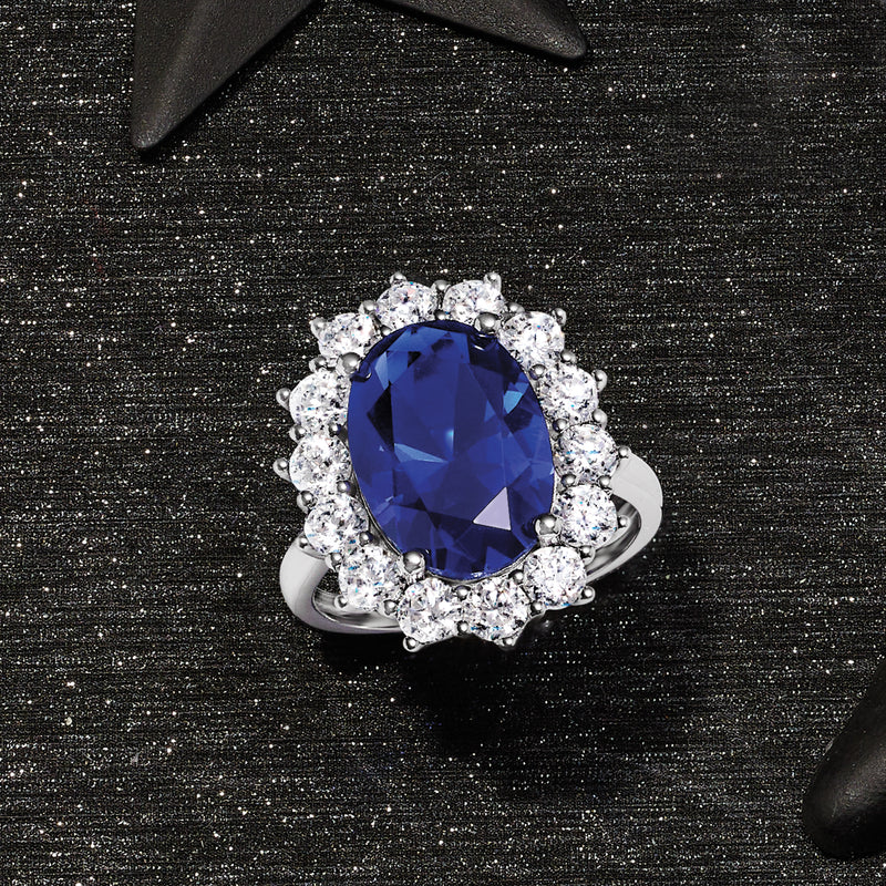 Sterling silver oval blue center ring with clear CZ halo and curved split shank