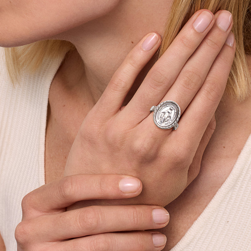 Sterling silver oval miraculous medal ring on hand, braided frame with central Virgin image