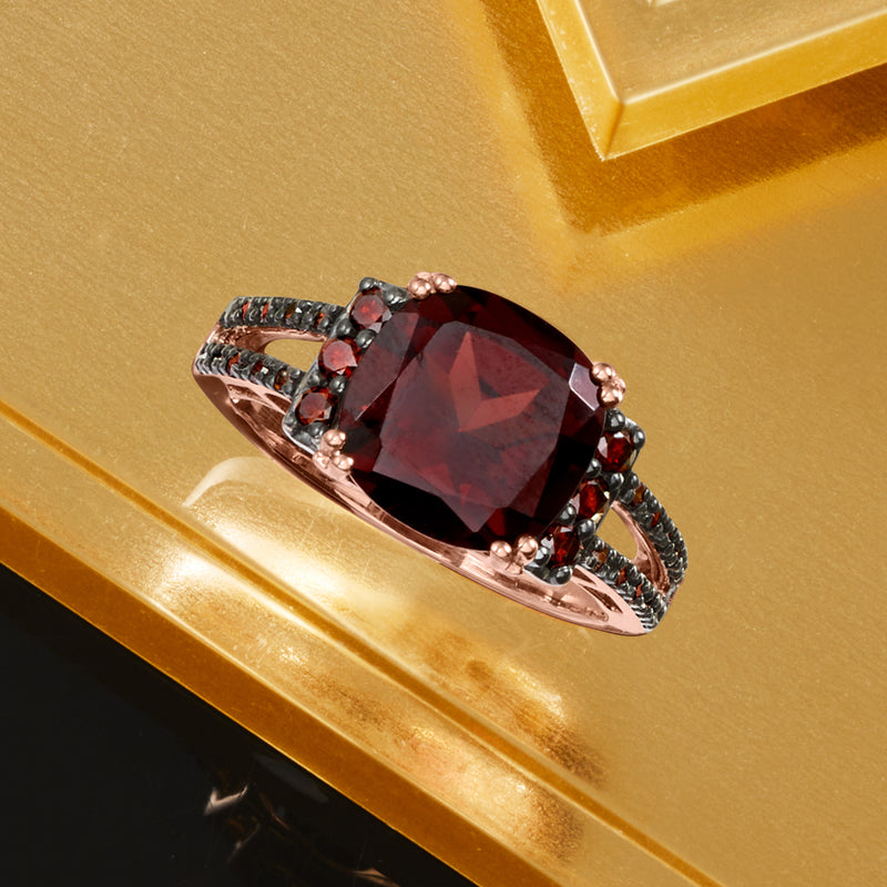 Rose gold ring with cushion-cut garnet and red diamond accents