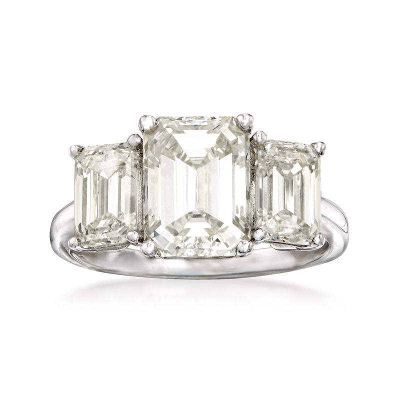 Three-stone diamond ring with rectangular-cut center and side stones, platinum band
