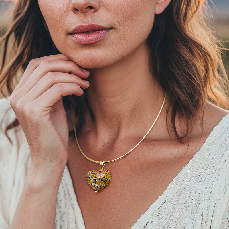 Multicolored heart pendant on thin gold chain, worn at neckline