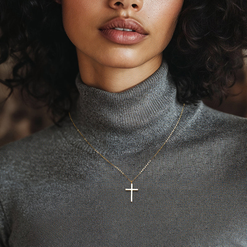 Yellow gold cross pendant necklace on the neck with fine link chain