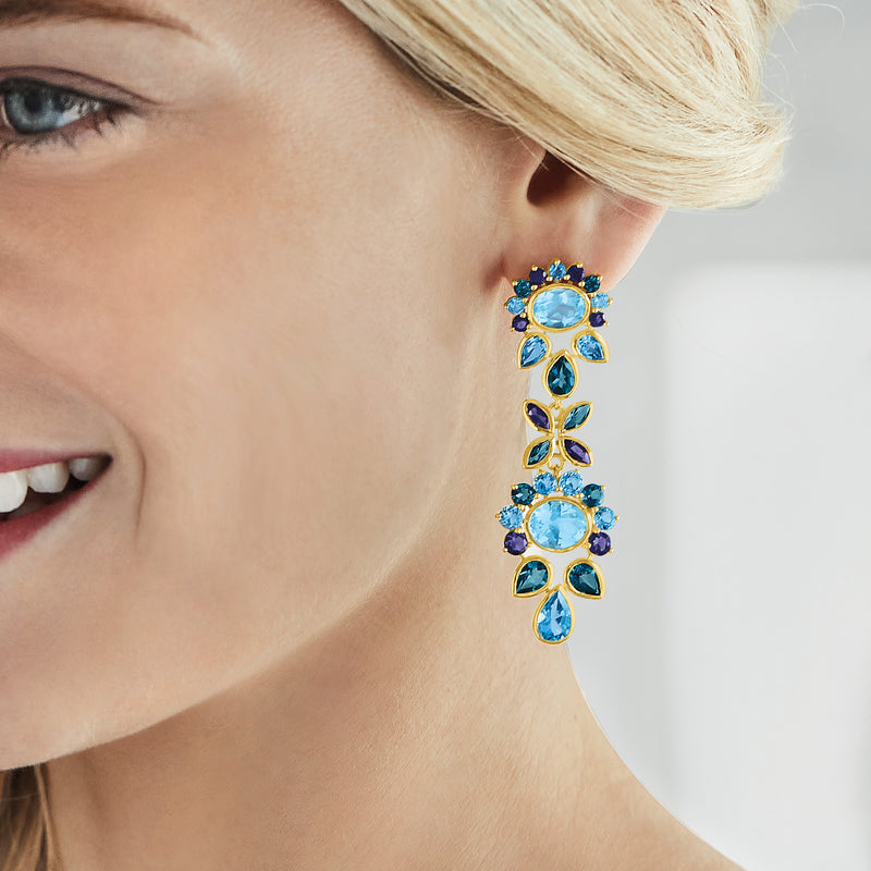 Gold-tone drop earrings on model: dangling oval light-blue stones with leaf accents