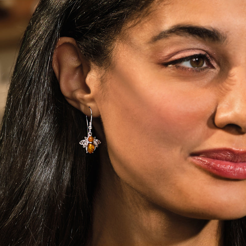 Sterling silver amber bee drop earrings worn on the ear