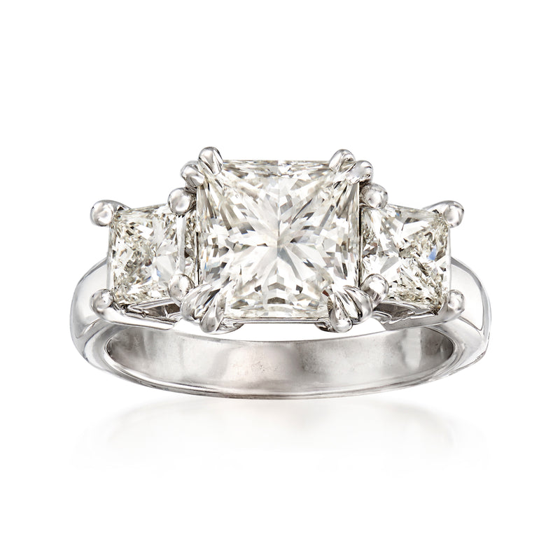 18kt white gold diamond ring with emerald-cut center stone and side princess-cut stones