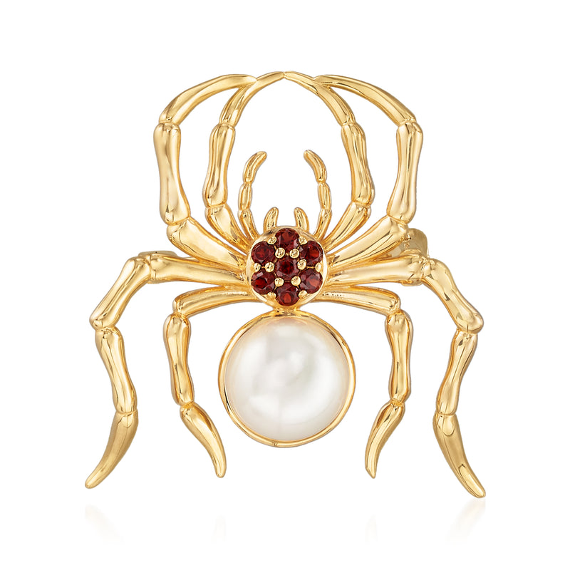 Gold-tone spider pin with round white pearl center and red garnet-style stones