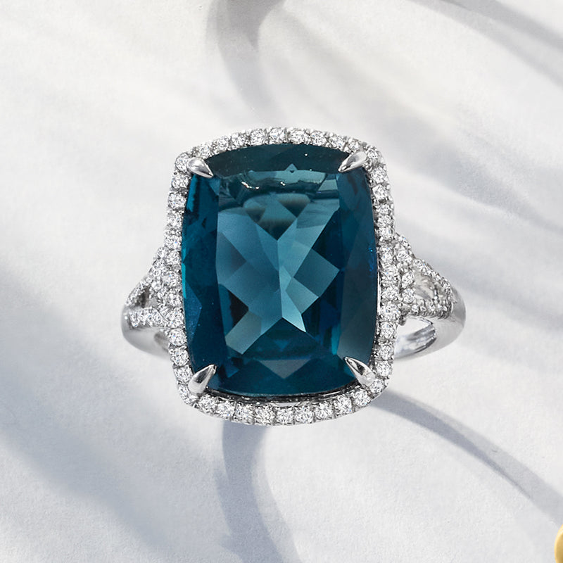 White gold ring with cushion-cut London blue topaz and diamond halo