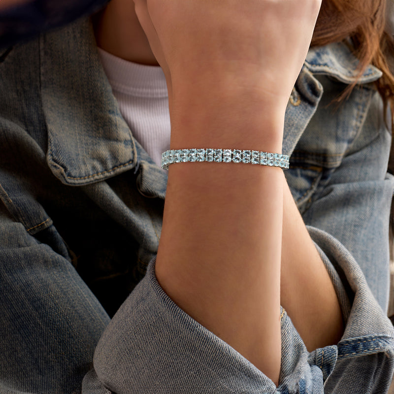Two-row tennis bracelet on wrist with light blue aquamarine stones in sterling silver