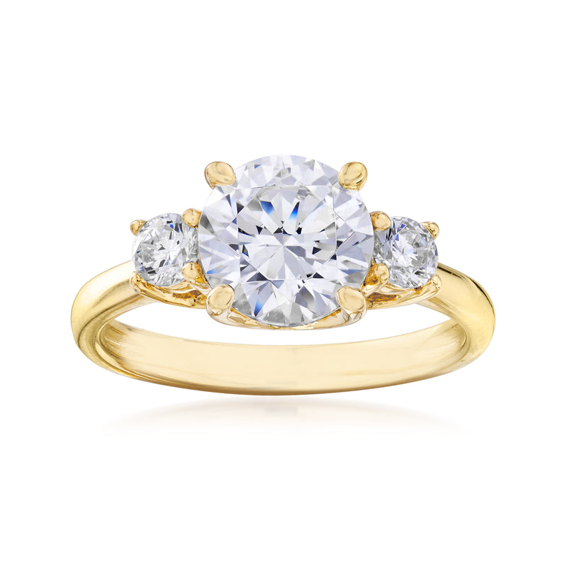 Three-stone CZ ring, round center stone with two side stones, gold-tone band