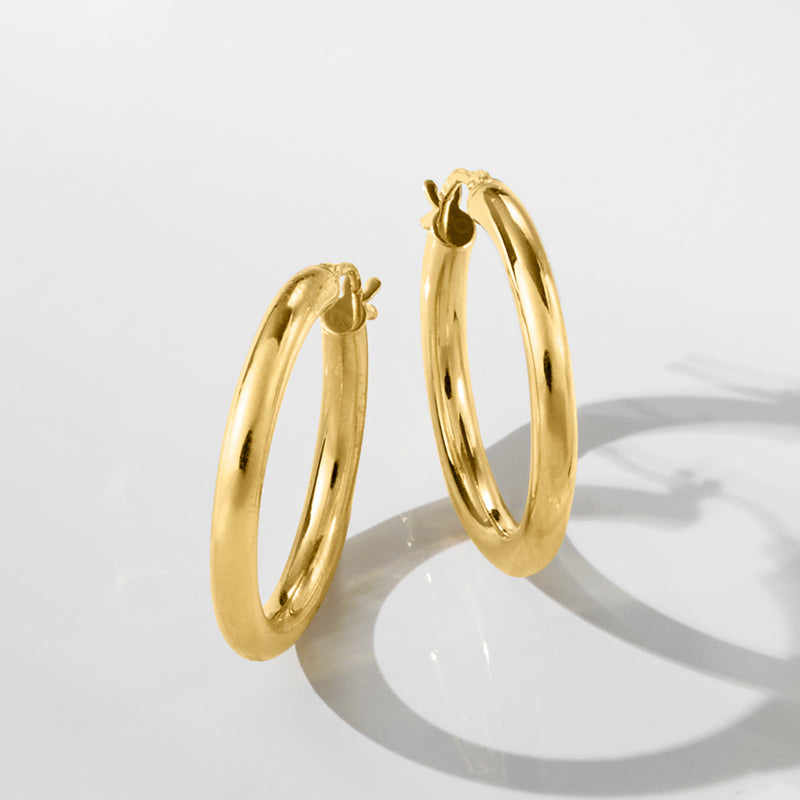 Polished 18kt yellow gold hoop earrings with hinged back and smooth oval profile