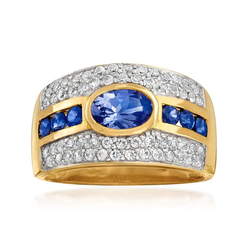 Gold-tone multi-stone ring with oval blue center, blue side stones, and clear round accents