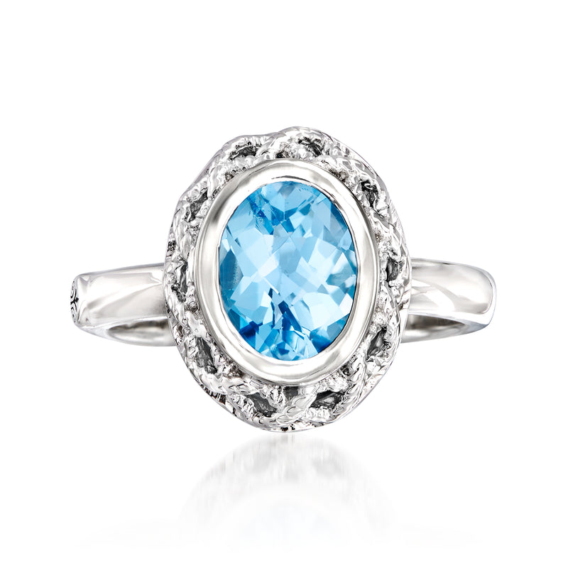 Sterling silver ring with oval blue topaz, textured halo setting and slim band