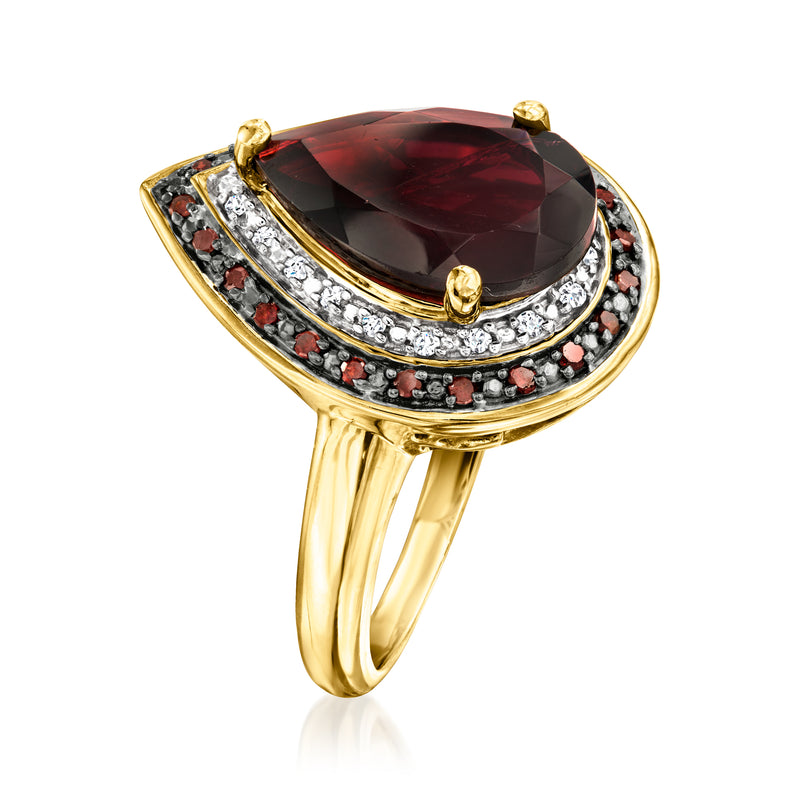 Teardrop-style ring with oval red garnet, white diamond accents, golden prong and band