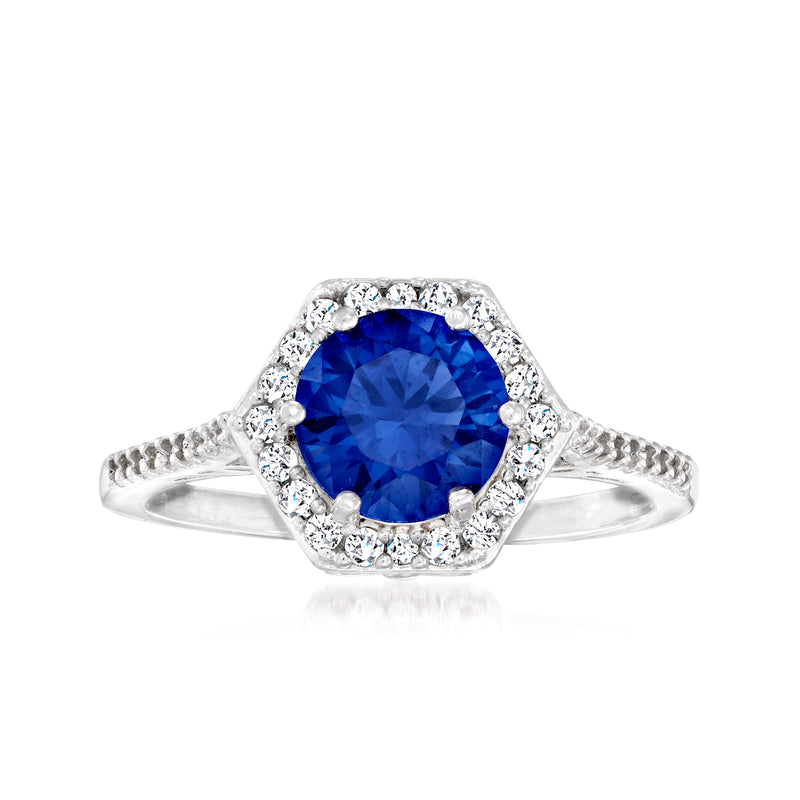 Sterling silver ring with large blue round-cut simulated sapphire and white stone halo