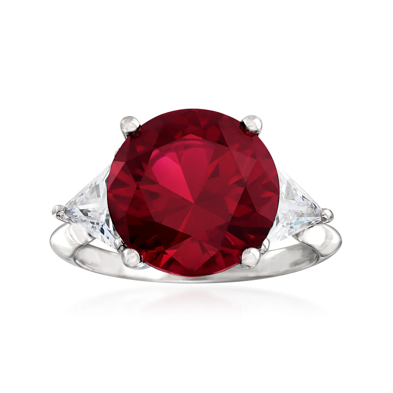 Sterling silver ring with large red oval gemstone and clear side accents, prong set