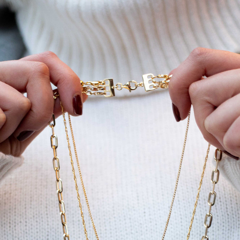 Gold over sterling layering clasp with rectangular links, held between hands