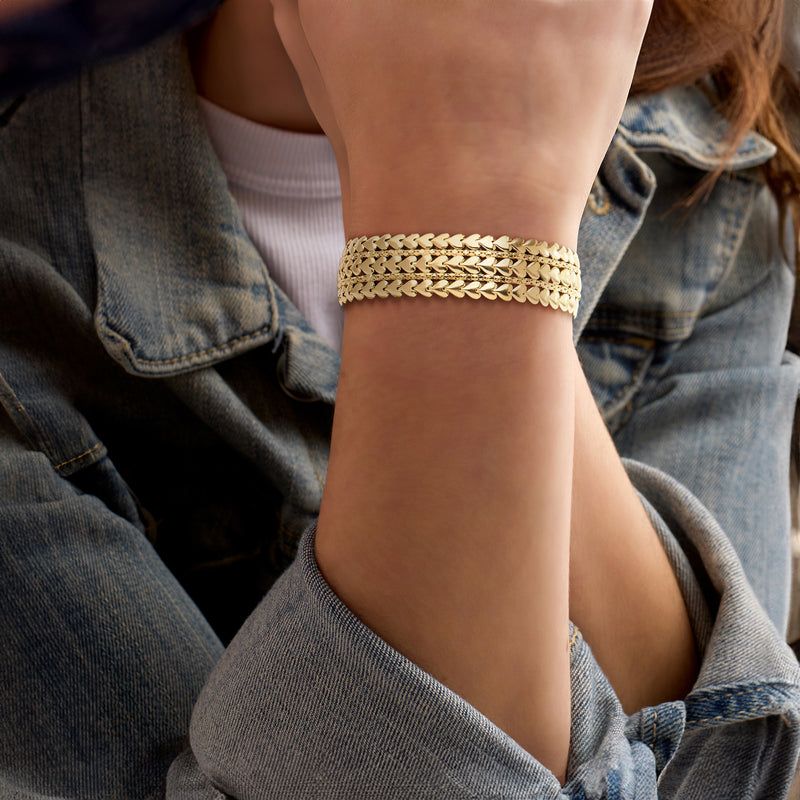 Gold-tone multi-row bracelet with heart-shaped links on wrist