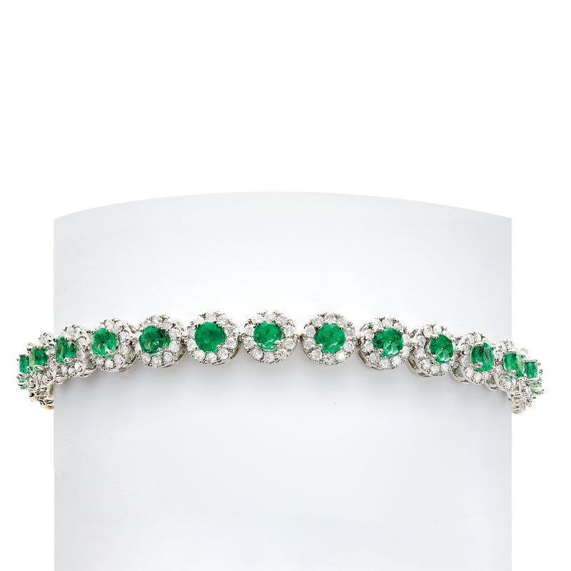 White gold tennis bracelet with round green gemstones and diamond halo links