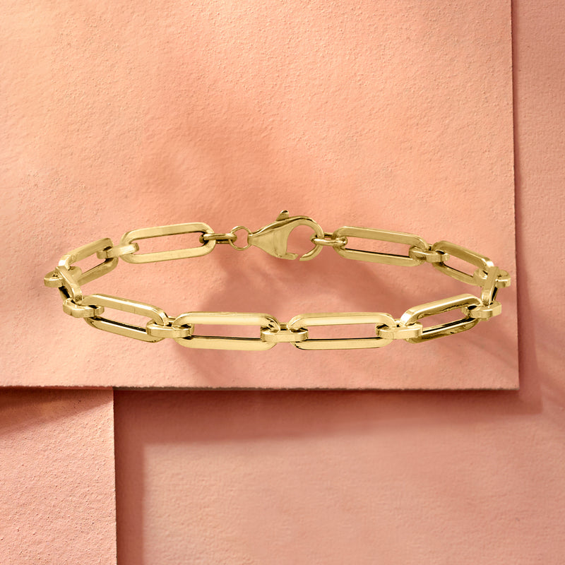 Yellow gold paper clip link bracelet on display card, hinged oval links