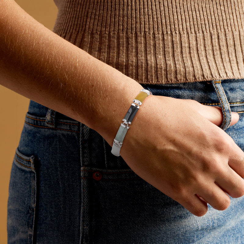 Sterling silver jade bracelet with multicolor inlays worn on wrist
